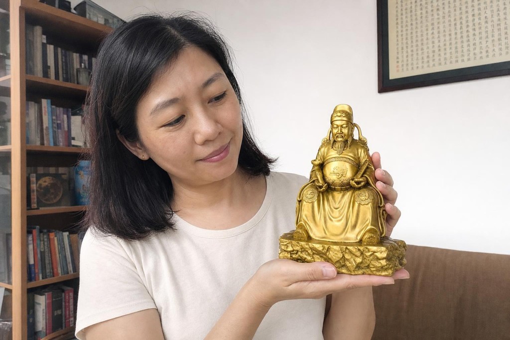 Wenchang Dijun statue held by a Chinese Australian woman in a home study setting