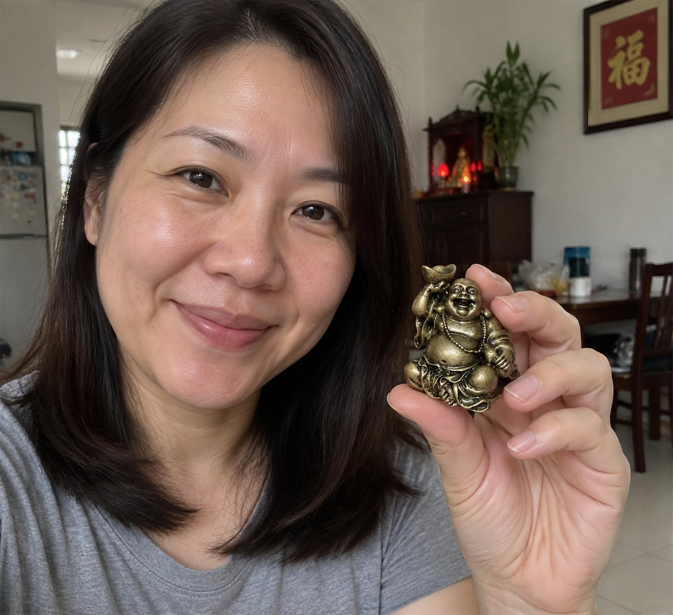 Mini Laughing Buddha 笑佛 bronze-colour resin statue in a home setting